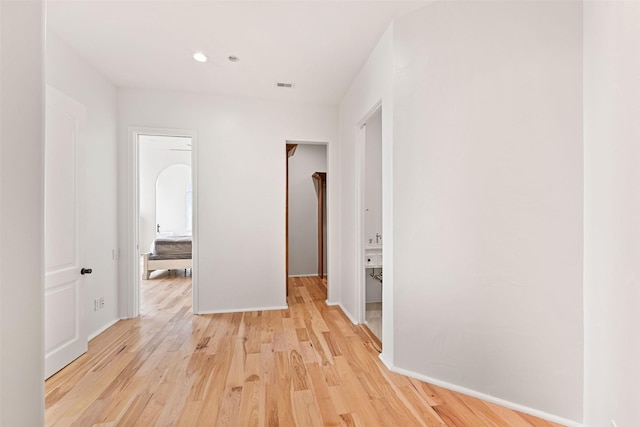 hall with light wood finished floors, recessed lighting, visible vents, and baseboards