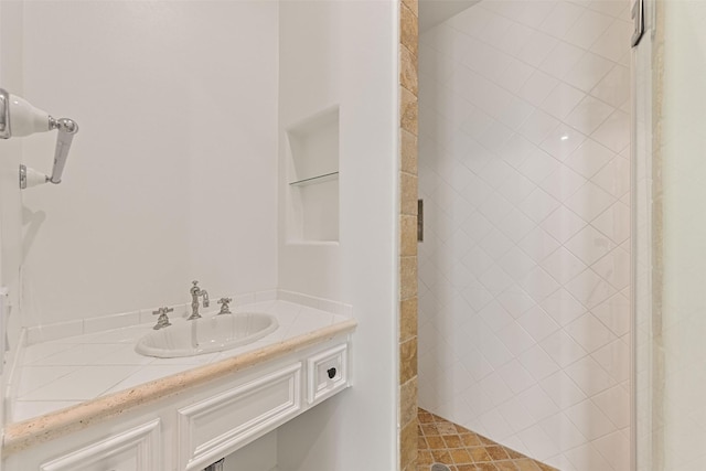 bathroom featuring tiled shower and vanity