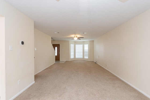 spare room with ceiling fan and light colored carpet