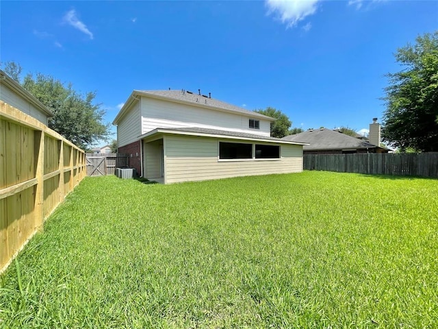 back of property featuring a yard and central AC