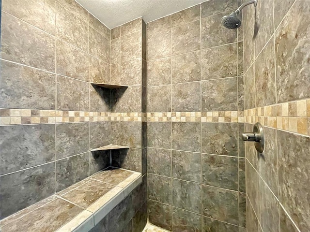 bathroom with tiled shower and a textured ceiling