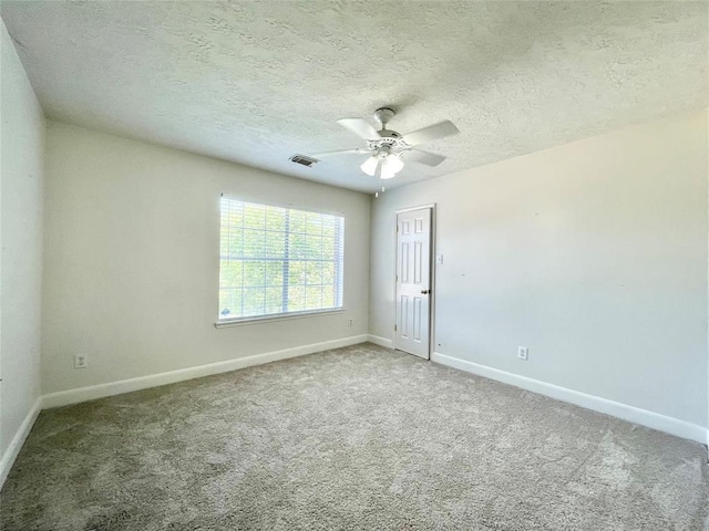 spare room with carpet flooring, ceiling fan, and a textured ceiling