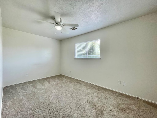 carpeted spare room featuring ceiling fan and a textured ceiling