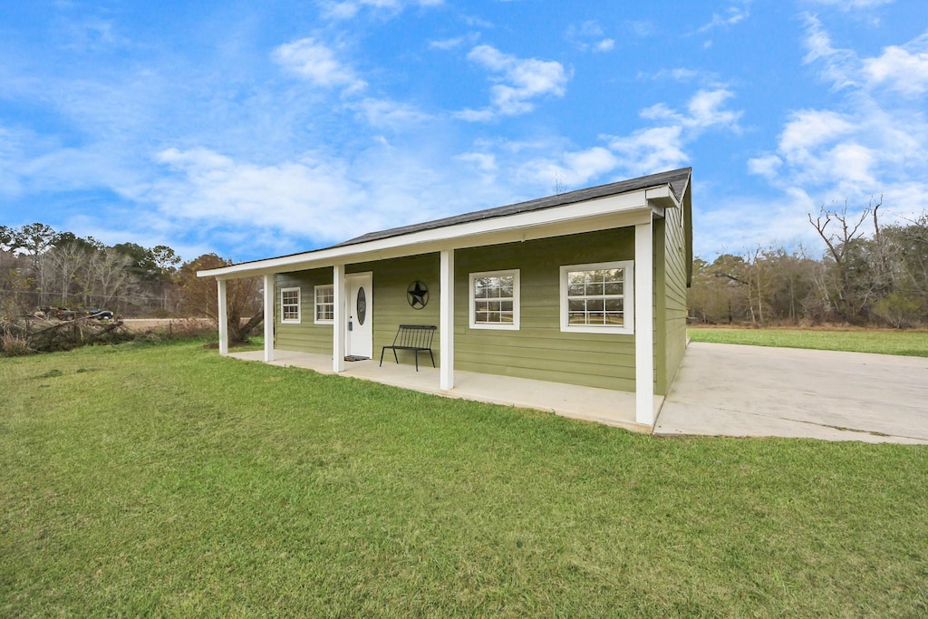 back of property featuring a yard and a patio