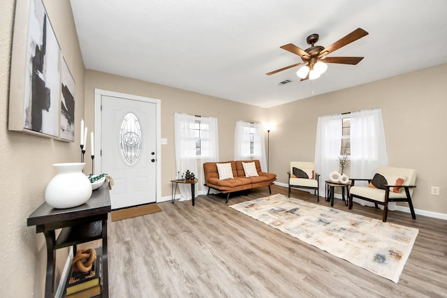 living room with ceiling fan, light hardwood / wood-style flooring, and a wealth of natural light