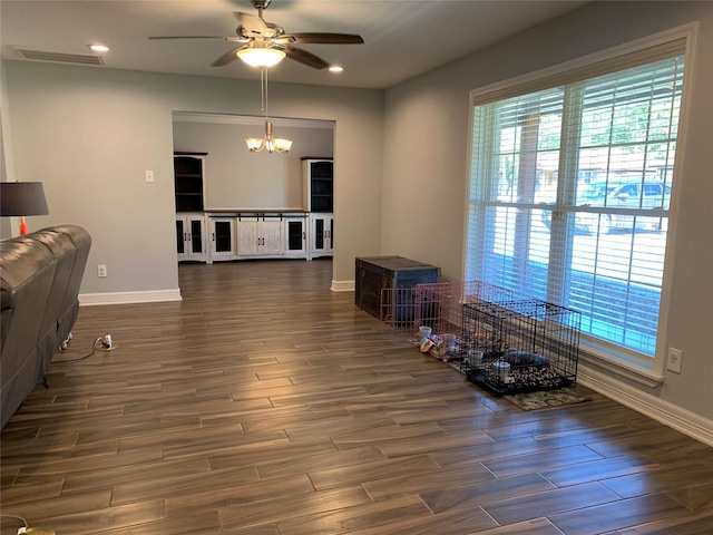 living room featuring ceiling fan with notable chandelier