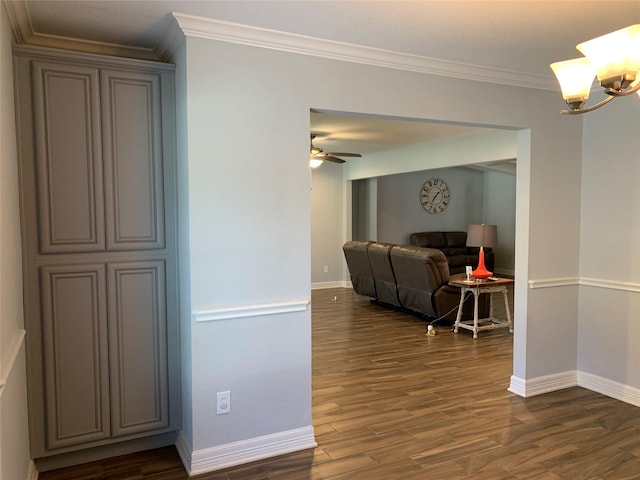 hall featuring dark hardwood / wood-style flooring, crown molding, and a chandelier