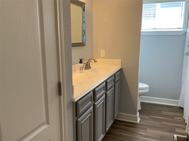 bathroom featuring toilet, hardwood / wood-style floors, and vanity