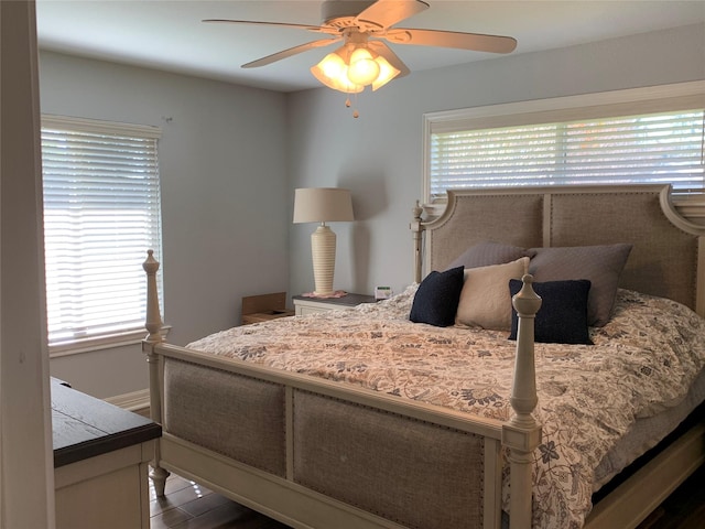 bedroom featuring ceiling fan, dark hardwood / wood-style floors, and multiple windows