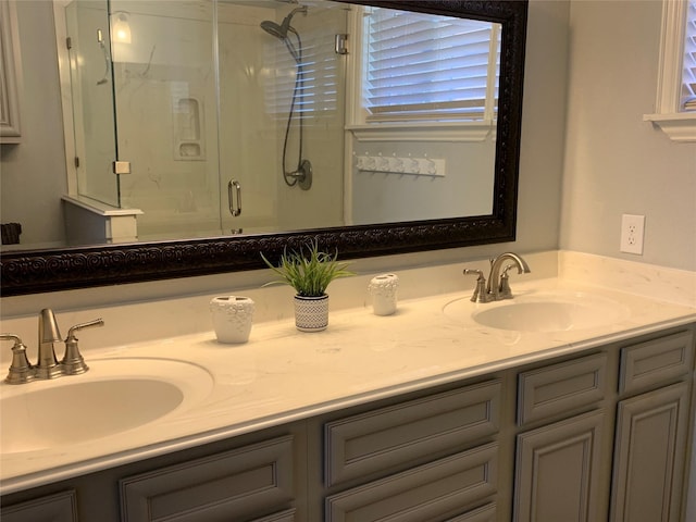 bathroom featuring a shower with shower door and vanity