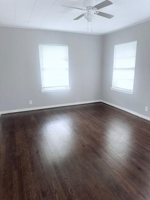 spare room featuring ceiling fan, dark hardwood / wood-style flooring, and a wealth of natural light