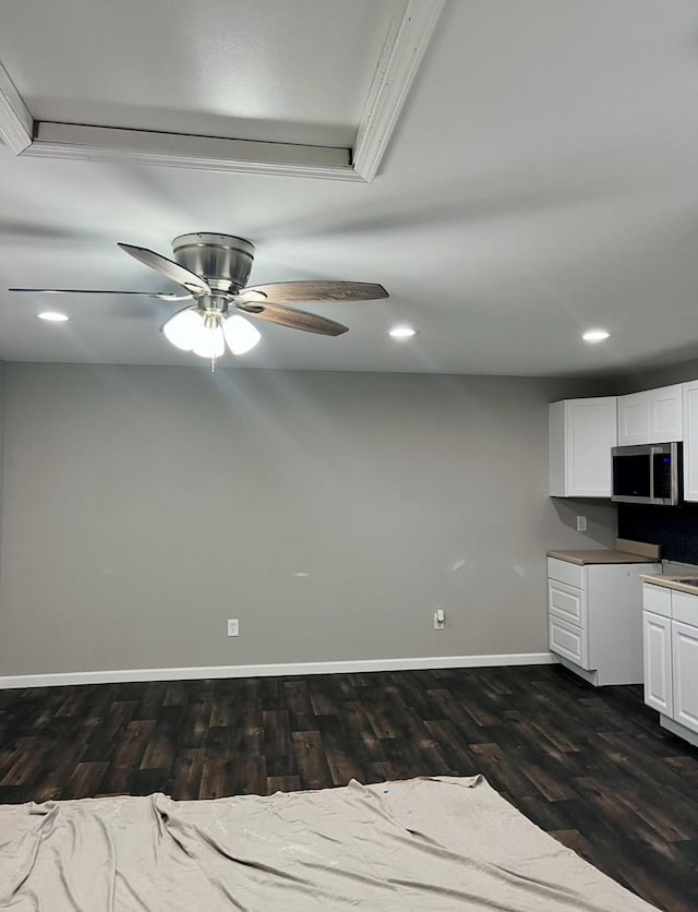 kitchen featuring white cabinets, dark hardwood / wood-style floors, ceiling fan, and crown molding