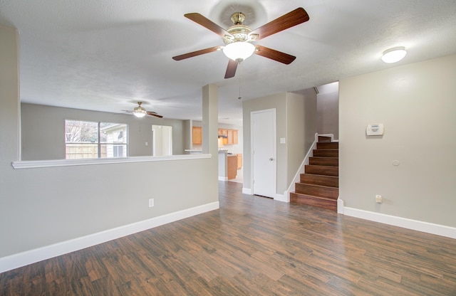 empty room with a textured ceiling, dark hardwood / wood-style floors, and ceiling fan