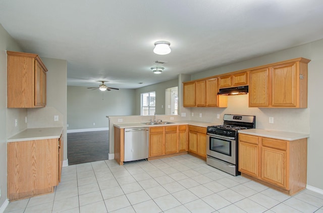 kitchen with ceiling fan, sink, kitchen peninsula, light tile patterned floors, and appliances with stainless steel finishes