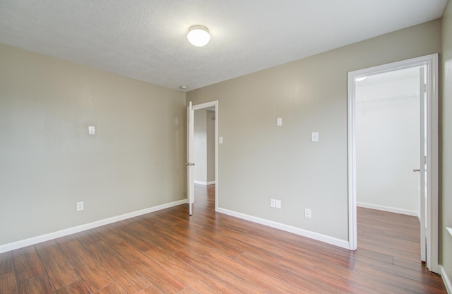 empty room featuring a textured ceiling and dark wood-type flooring