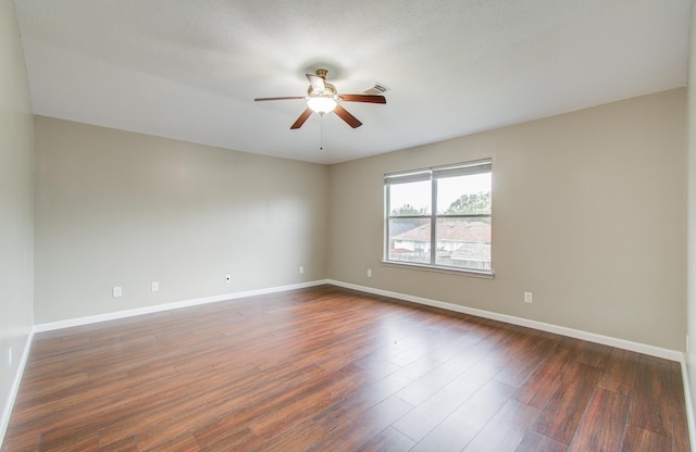 spare room featuring ceiling fan and dark wood-type flooring