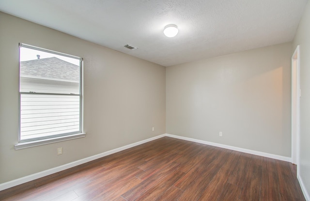 spare room with dark hardwood / wood-style flooring and a textured ceiling