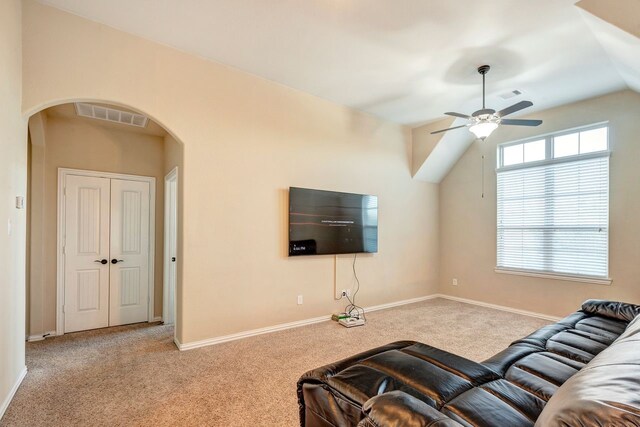 carpeted living room with lofted ceiling and ceiling fan