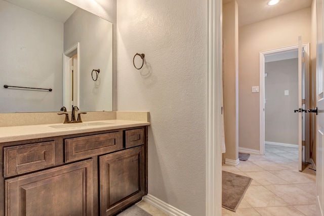 bathroom featuring vanity, baseboards, and tile patterned floors