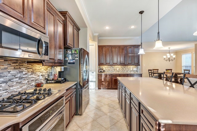 kitchen featuring stainless steel appliances, ornamental molding, pendant lighting, and light tile patterned floors