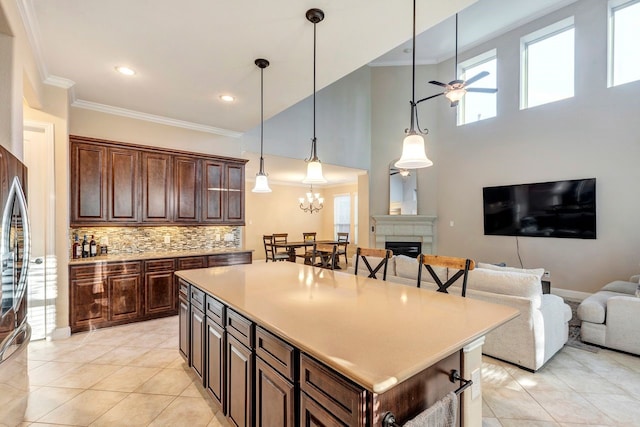 kitchen with tasteful backsplash, a fireplace, ornamental molding, and open floor plan