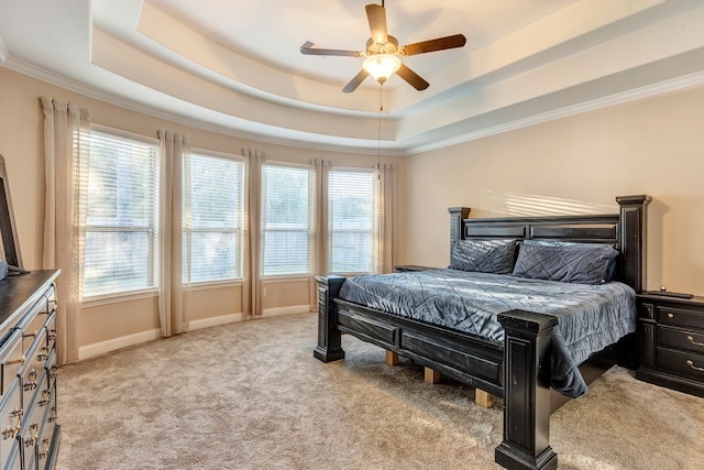 bedroom featuring ornamental molding, light carpet, ceiling fan, and a tray ceiling