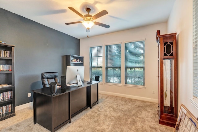 office space with light carpet, ceiling fan, and baseboards