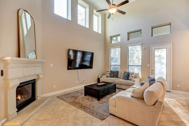 living room with a premium fireplace, plenty of natural light, light tile patterned floors, and ceiling fan