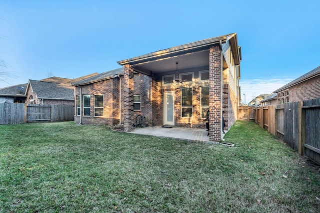 back of house with a patio area, ceiling fan, and a lawn