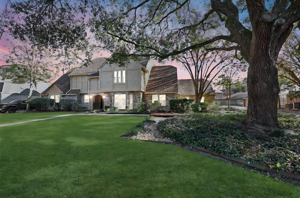 tudor-style house featuring a lawn