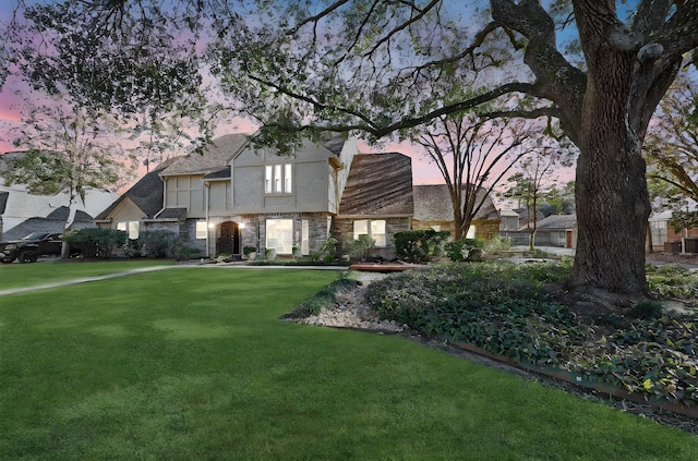 tudor-style house featuring a lawn