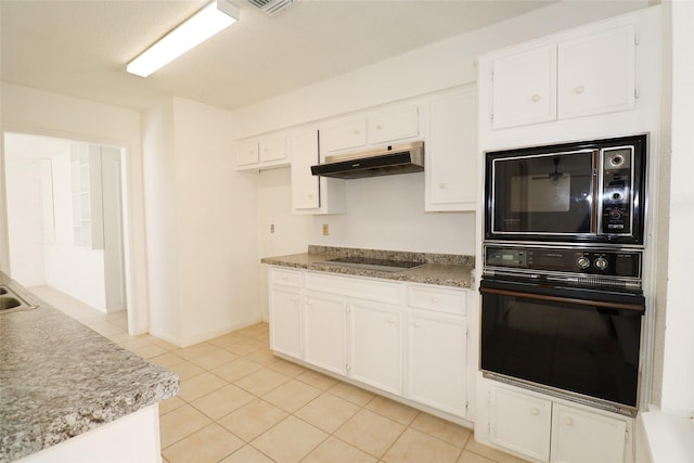 kitchen featuring white cabinets, light tile patterned floors, and black appliances