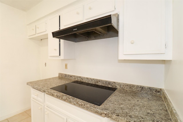 kitchen with black electric stovetop, white cabinetry, and light tile patterned floors