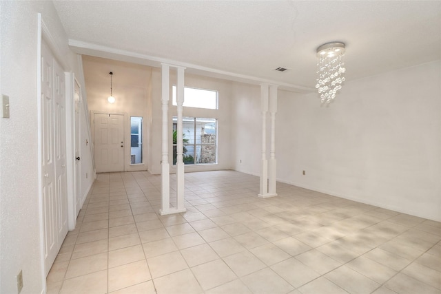 interior space with light tile patterned flooring, a high ceiling, and a chandelier