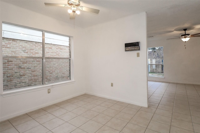 spare room with ceiling fan and light tile patterned flooring