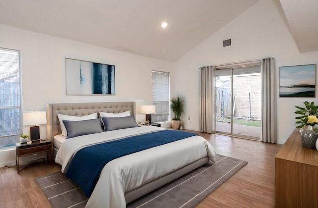 bedroom featuring access to outside, lofted ceiling, and hardwood / wood-style flooring