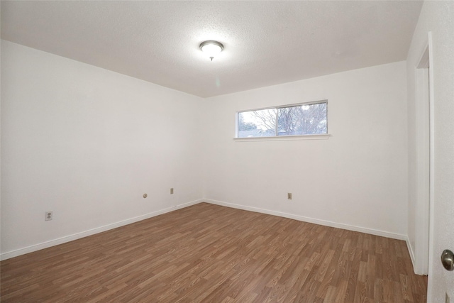 unfurnished room with hardwood / wood-style floors and a textured ceiling