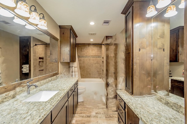 full bathroom featuring hardwood / wood-style flooring, vanity, toilet, and tiled shower / bath