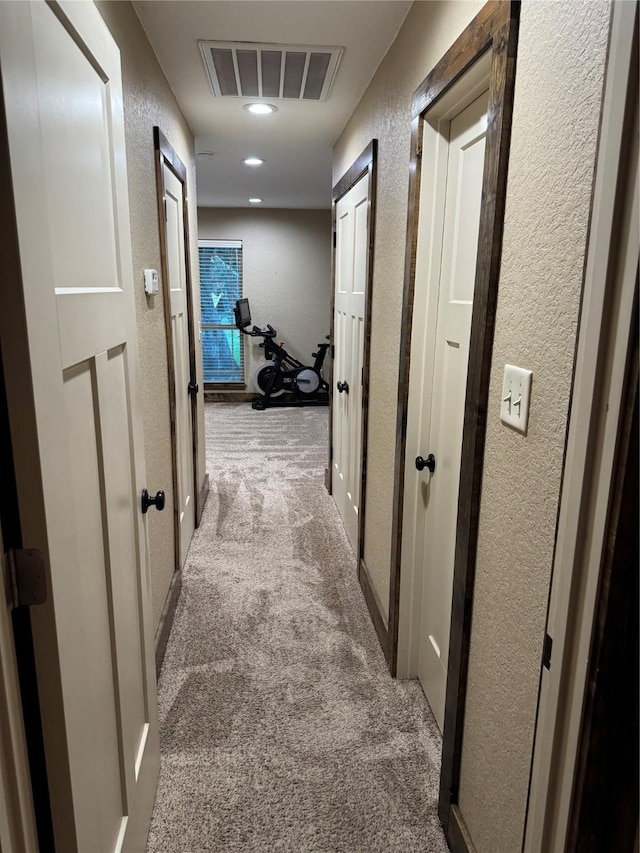 hallway featuring light colored carpet