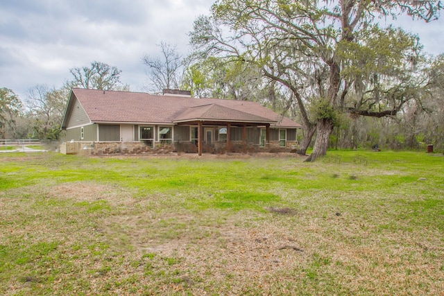 back of property with a lawn