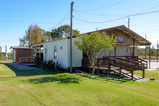 exterior space featuring a wooden deck, a storage shed, and a lawn