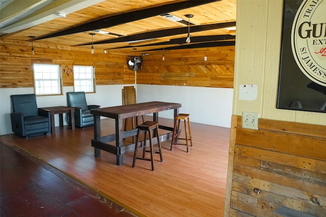 dining room with beam ceiling, wooden ceiling, and hardwood / wood-style floors