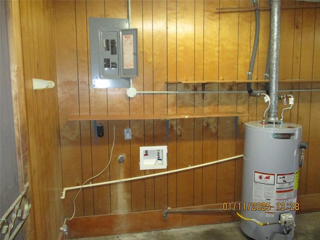 utility room featuring electric panel and gas water heater