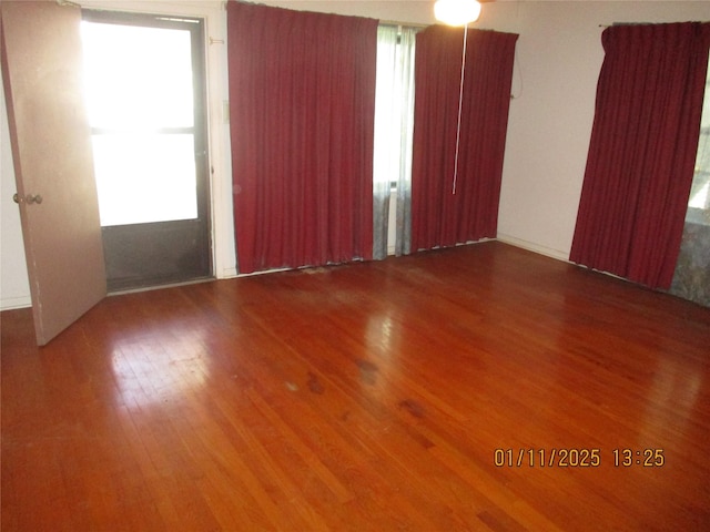 unfurnished room with hardwood / wood-style flooring and plenty of natural light