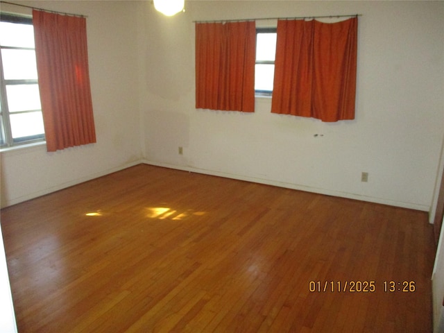 unfurnished room featuring wood-type flooring and plenty of natural light