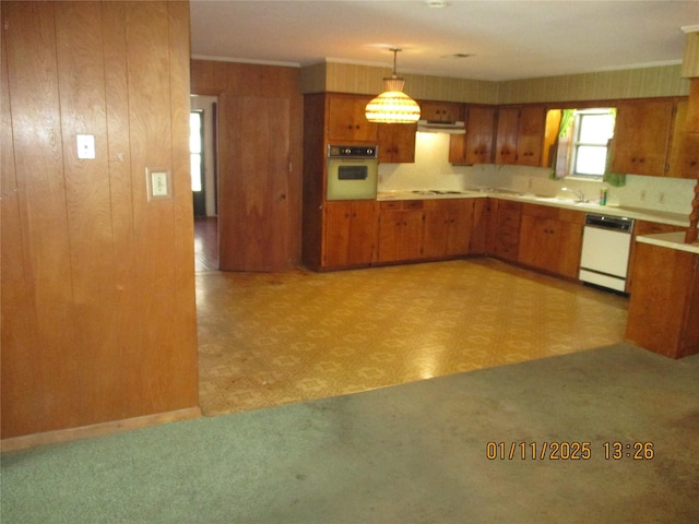 kitchen with white appliances, decorative light fixtures, and wooden walls