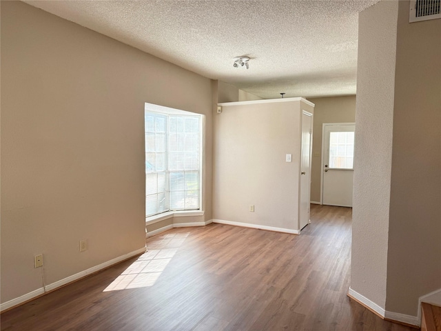 empty room featuring hardwood / wood-style floors and a textured ceiling