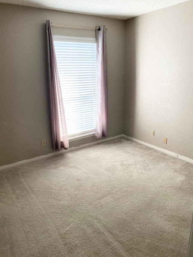 unfurnished room featuring carpet flooring and a textured ceiling