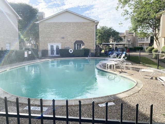 view of pool with french doors and a patio