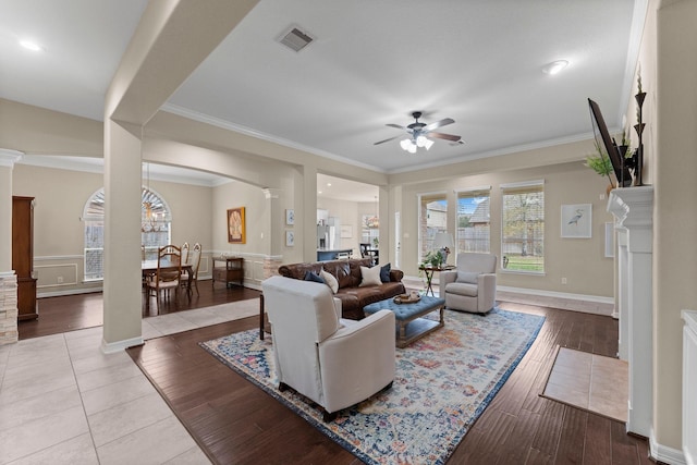 living room featuring ceiling fan, ornamental molding, decorative columns, and light hardwood / wood-style flooring